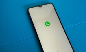 a white and black phone with a green whatsapp sticker on it
